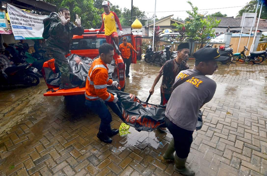 Rescuers carry body bags of victims after the Indonesian tsunami as the death toll is expected to rise.