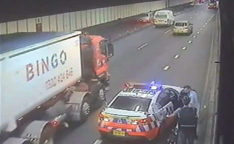 A police officer with a food delivery cyclist in the tunnel.  
