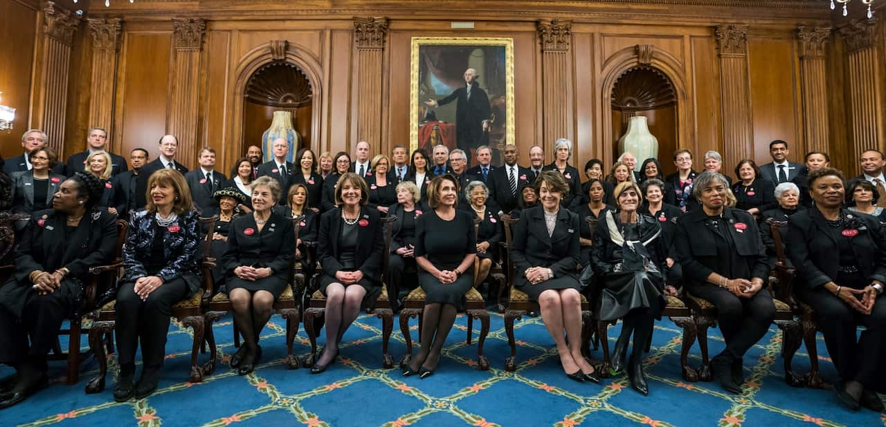 Democratic House Minority Leader Nancy Pelosi (C), along with Democratic members of the House and Senate, pose for photographs while wearing black (AAP)
