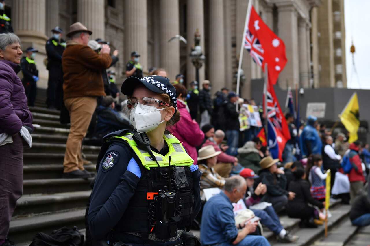 People are seen during a demonstration outside the Victorian State Parliament in Melbourne, Tuesday, November 16, 2021. The Victorian government has made several changes to its pandemic legislation to address legal and human rights concerns, ahead of deba