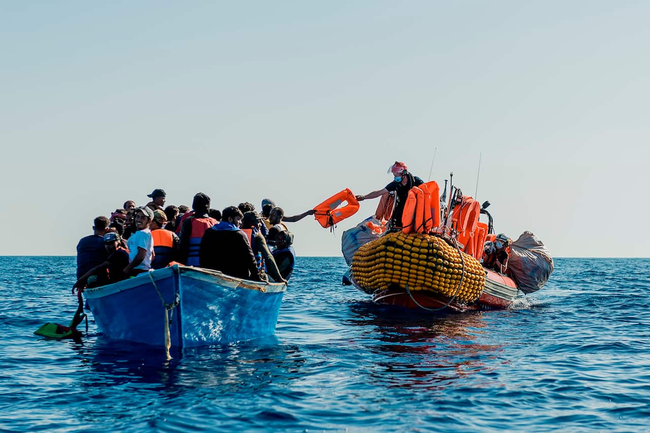 In this photo taken on Tuesday, June 30, 2020, a dinghy of the Ocean Viking vessel, right, approaches a boat carrying migrants during a rescue operation.