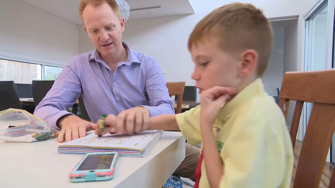 Sean Rapley and his son, Luke, practice writing the alphabet
