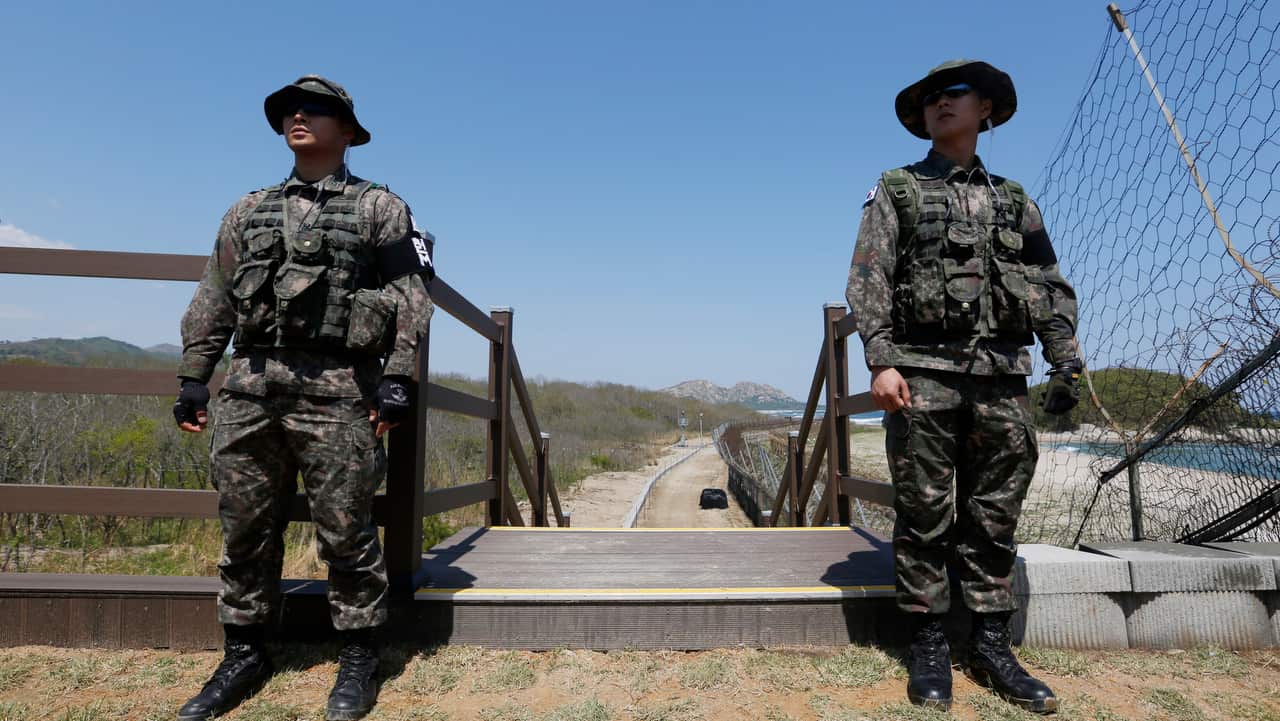 South Korean soldiers stand guard as people visit the 'DMZ Peace Trail'.