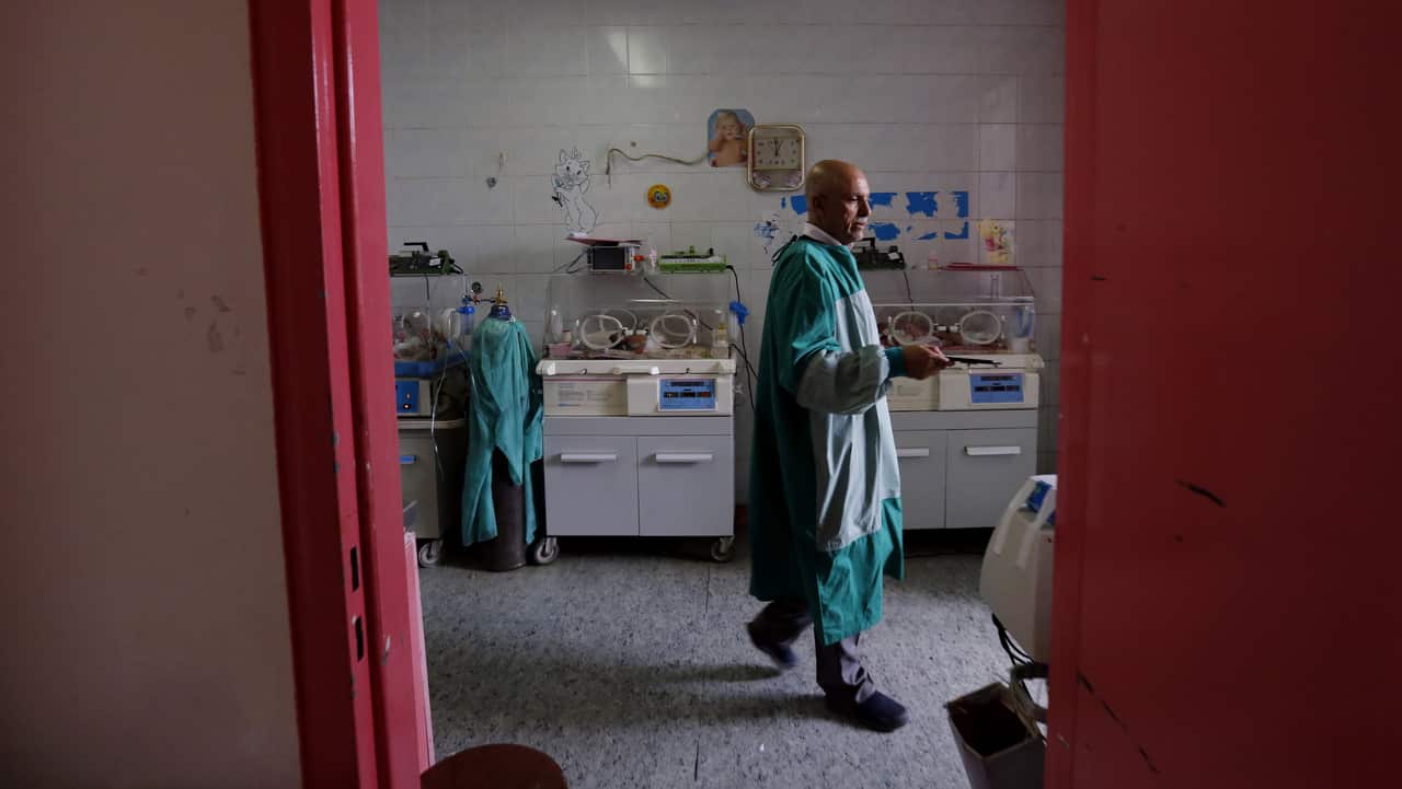 Yemeni doctor Faisal Al-Babli, head of children department at Al-Thawra Hospital, checks up the conjoined twins at Al-Thawra hospital, in Sana'a,