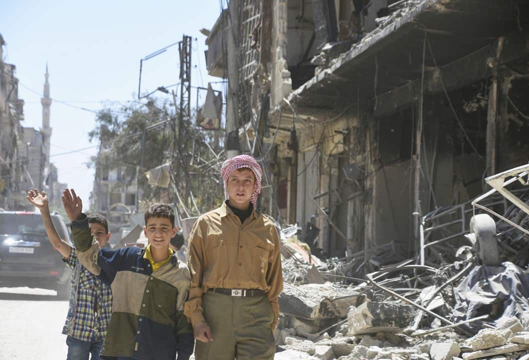 Children walk in a devastated area of Douma where chemical weapons were suspected to have been used against citizens. 