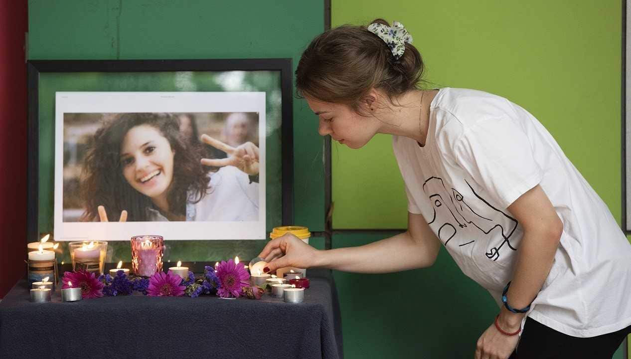 A student lights a candle at the vigil for international student Aiia Maasarwe.