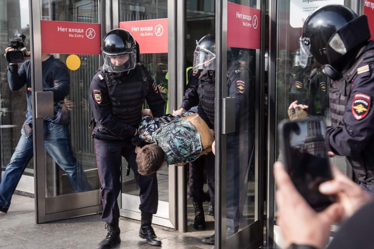 Police officers detain a man during an unsanctioned rally in the centre of Moscow, Russia. 
