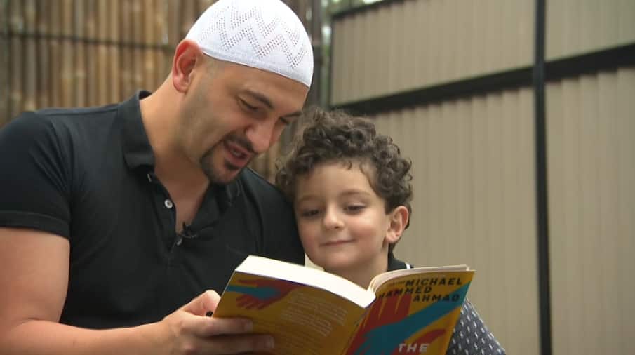 Dr Michael Mohammed Ahmad reading his new book The Other Half of You, with his son Kahlil. 
