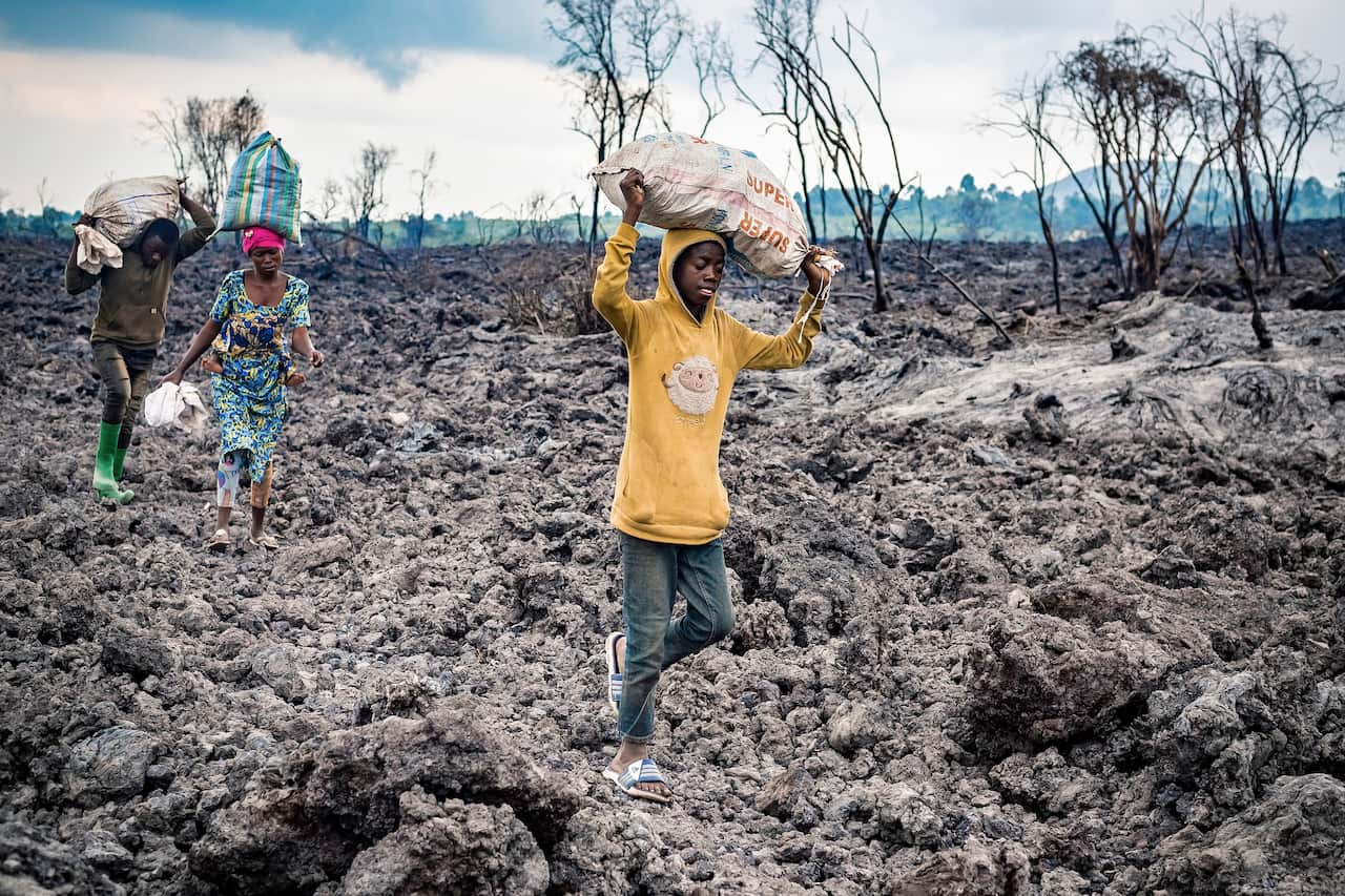 Congolese evacuate across cooled lava from the town of Goma in the aftermath of Mount Nyiragongo volcano over Goma.