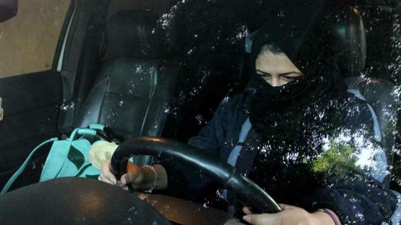 A woman sits behind the wheel of a car in Riyadh, Saudi Arabia.