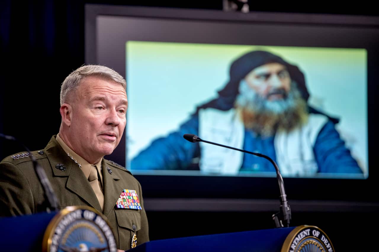 Abu Bakr al-Baghdadi is displayed on a monitor as General McKenzie speaks at a joint press briefing at the Pentagon.
