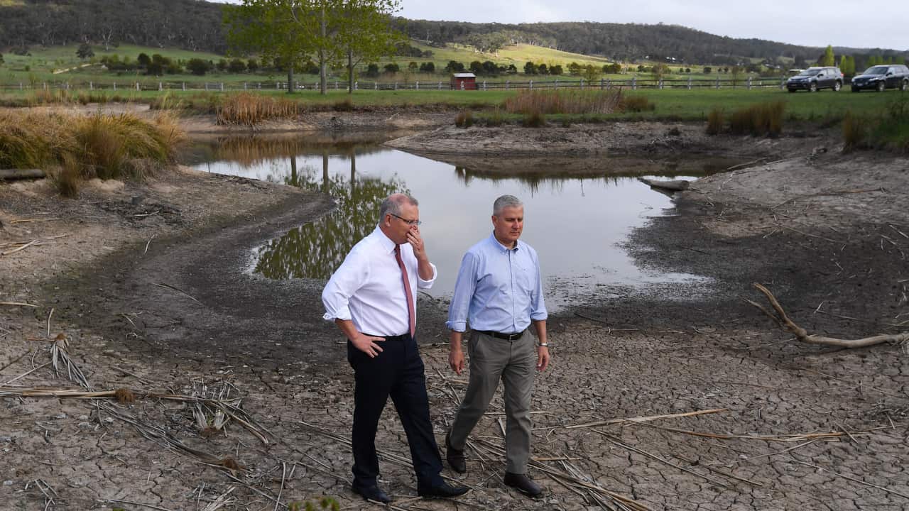 Prime Minister Scott Morrison and Deputy Prime Minister Michael McCormack walk along a dry damn during a visit to Mulloon Creek Natural Farm near Bungendore.