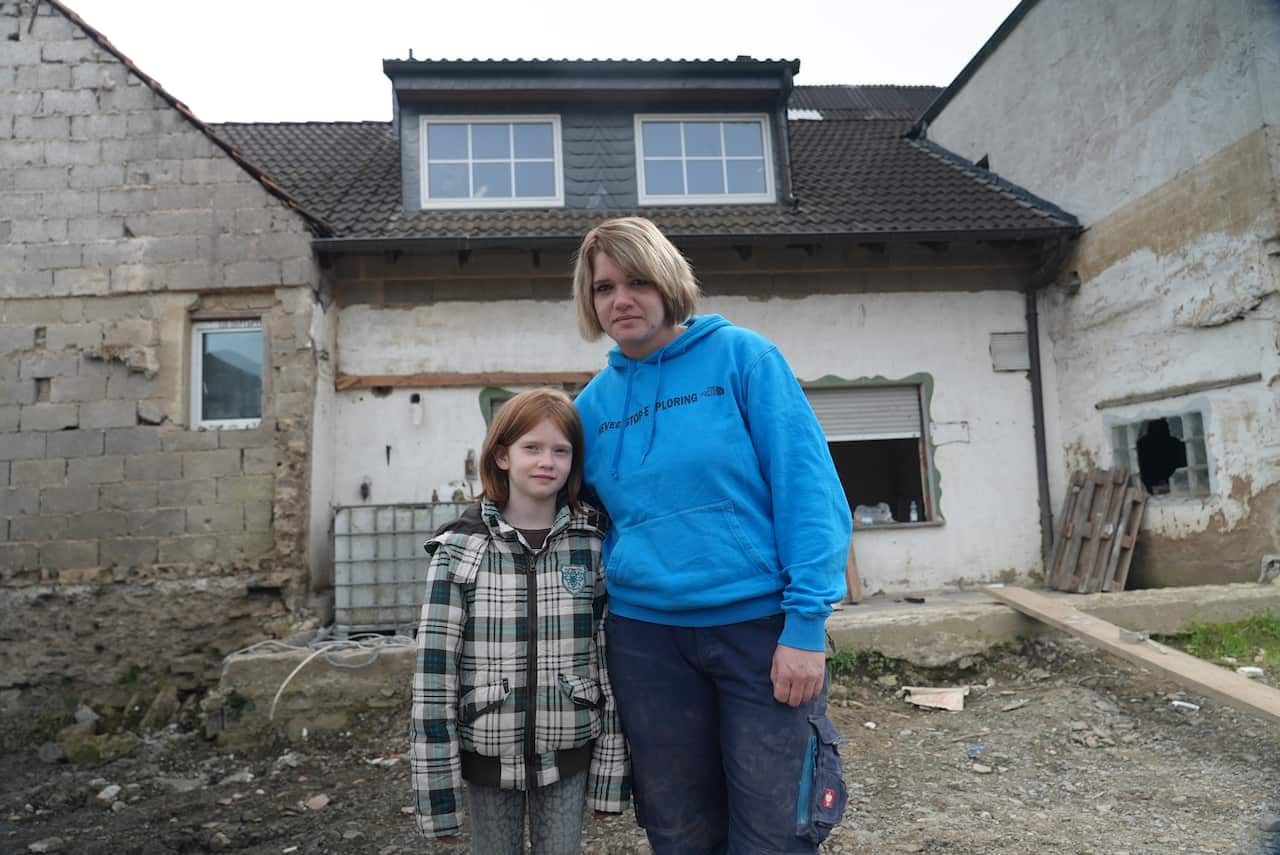 Julia Henrichs and her daughter outside her father's property in Schuld.