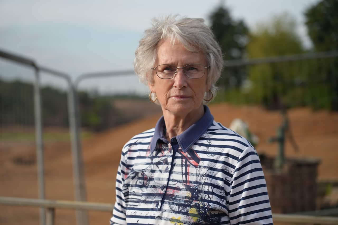Waltraud Groten in her backyard, standing in front of fencing, near the Erftstadt sinkhole. 