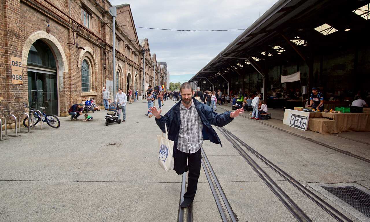 Artist Thom Roberts seeing himself and everyone around him as buildings and trains. Here he is seeing one of his latest works hung in Sydney.  