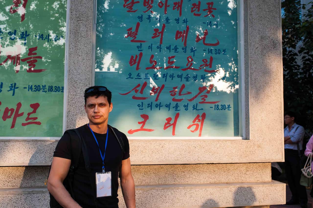 Ivan Sen together with the noticeboard outside of Taedongmun Cinema where Mystery Road’s screening details were listed. (Photo credit: Alek Sigley)