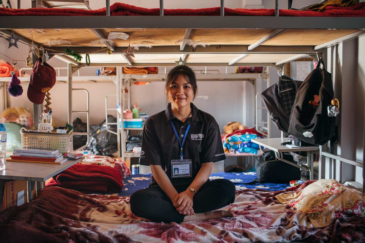 18-year-old Duang from Koto school sits on her bed