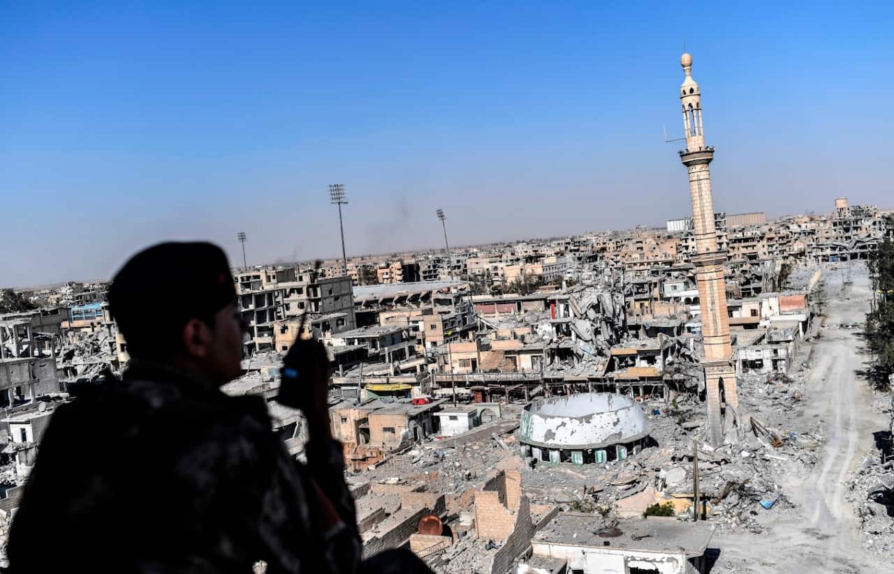 A member of the Syrian Democratic Forces (SDF), backed by US special forces, monitors the a from a building near Raqqa's stadium (Getty)