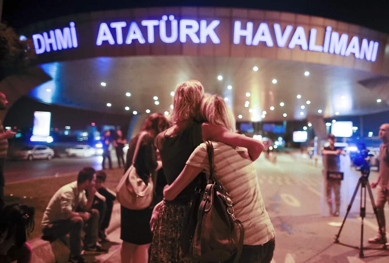 Passengers embrace each other at the entrance to Istanbul's Ataturk airport,