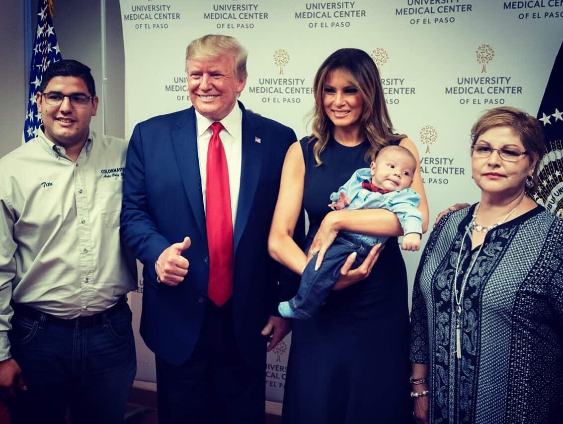US President Donald Trump delivers a thumbs up while posing with an baby boy orphaned in the El Paso shooting.