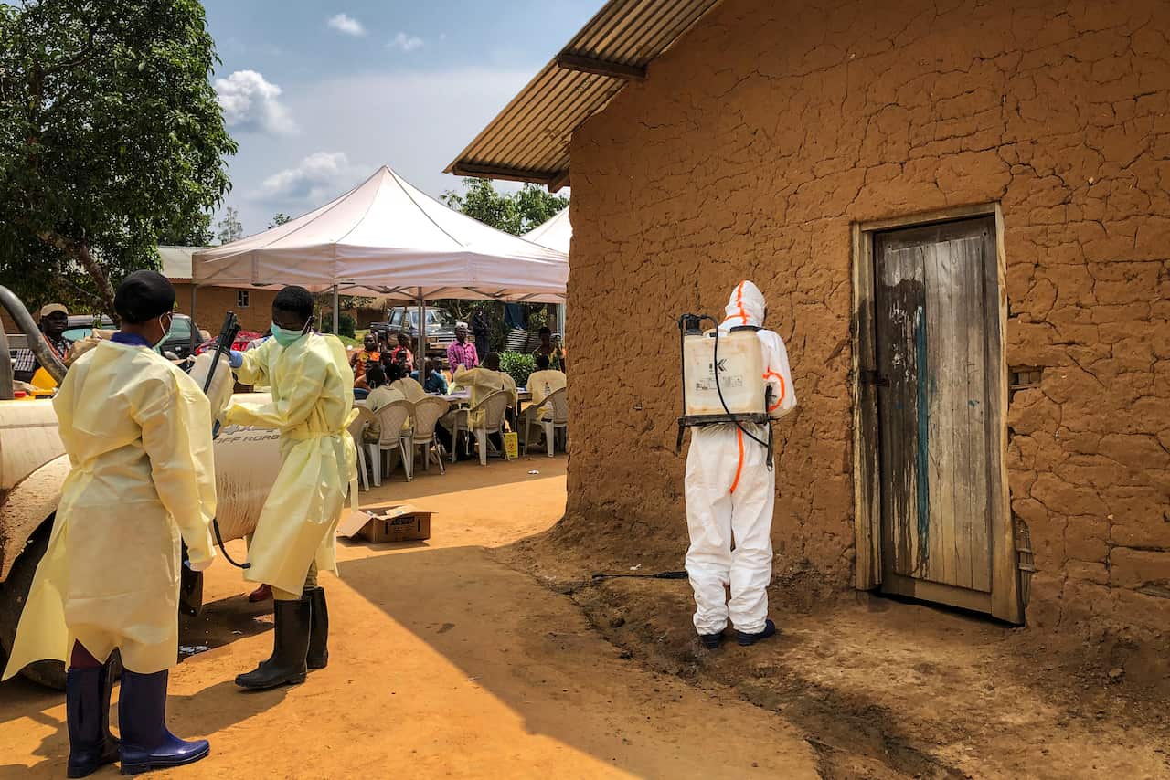 A worker from the World Health Organization decontaminates the doorway of a house in the village of Mabalako, in eastern Congo last month.