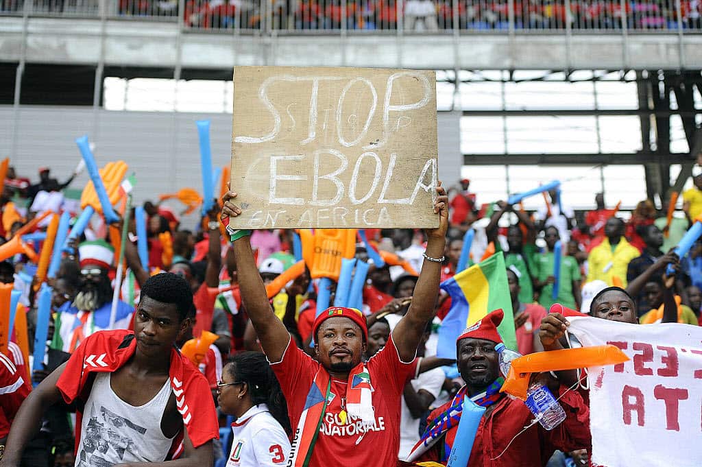 A football fan holds a placard reading 'Stop Ebola in Africa' ahead of the 2015 African Cup.