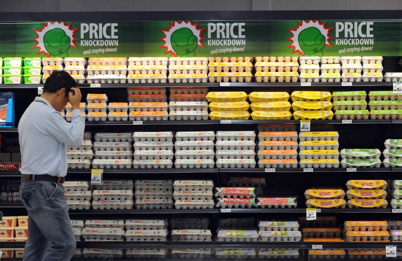 File photo of a shopper inspecting eggs inside a supermarket (AAP)
