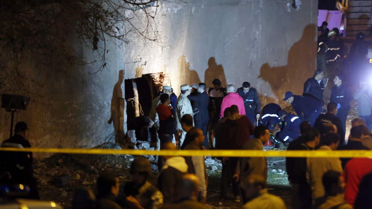 Security personnel inspect the scene of the bomb explosion.
