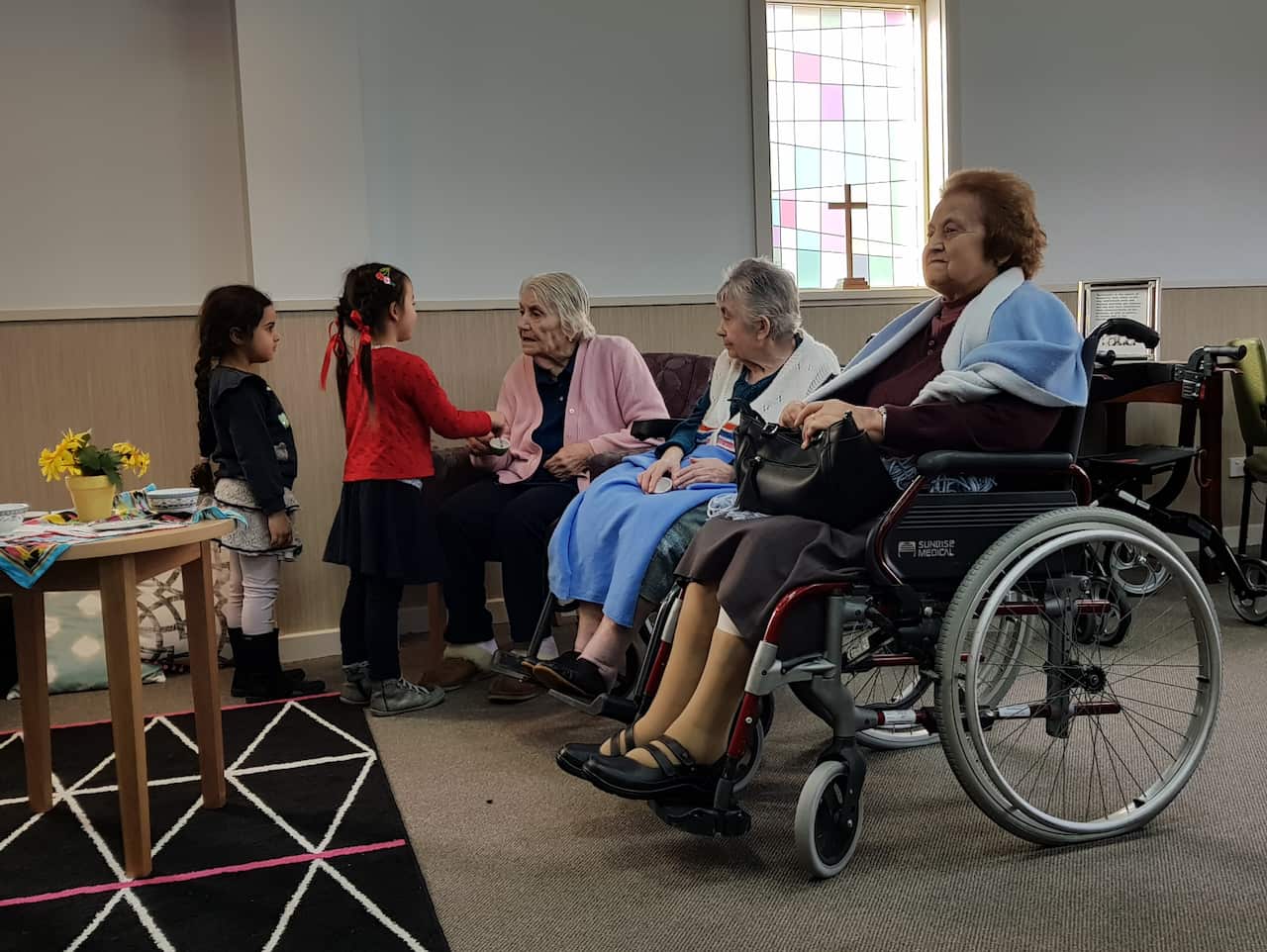 Nursing home residents play tea parties with visiting children.