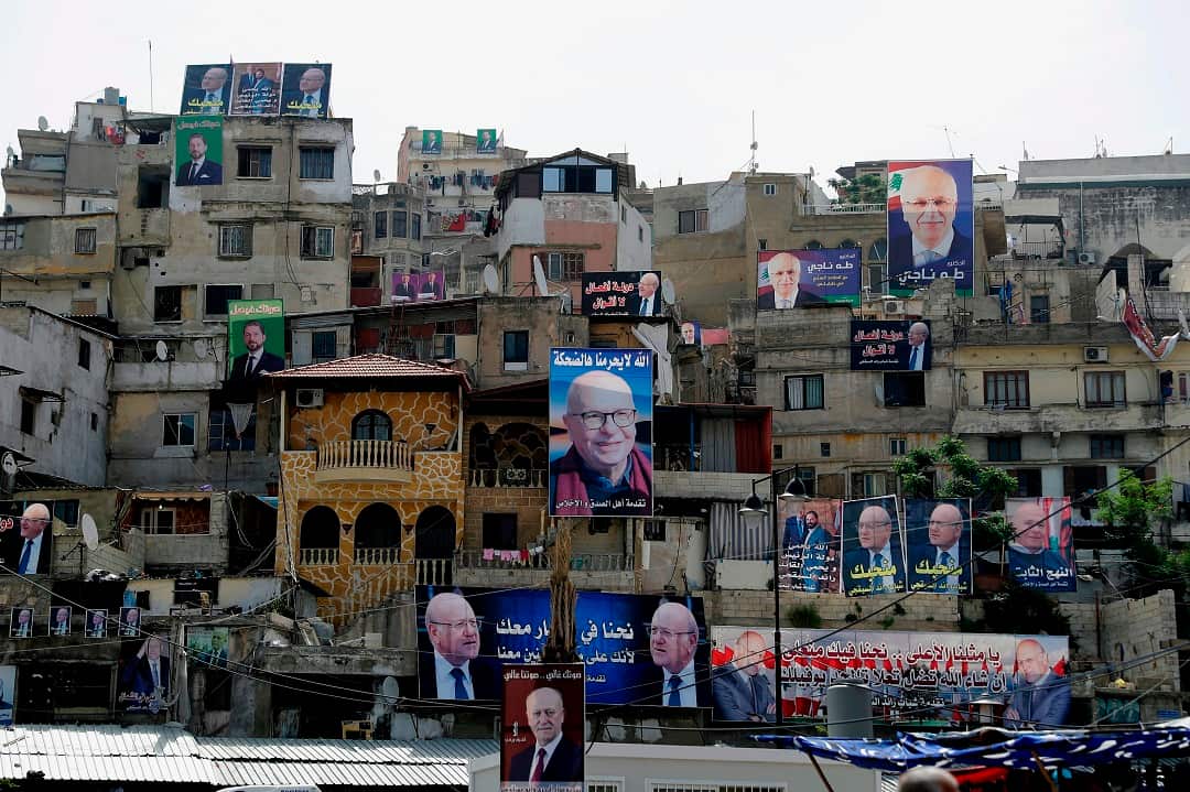 Posters of candidates for the upcoming Lebanese parliamentary elections hang on the walls of buildings in Tripoli.