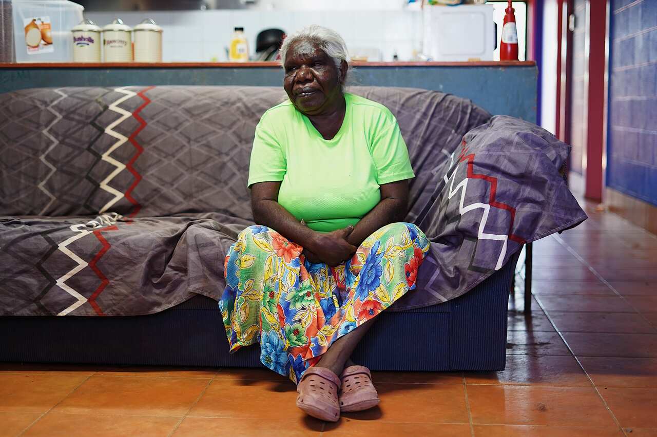                     Mudburra woman Elizabeth Henderson who lives in Elliott sits in the dark to keep cool during the dry season but needs air conditioning during hotter months           