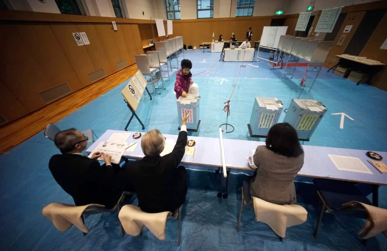 A voter casts her ballot in general election at a polling station in Tokyo Sunday, Oct. 22, 2017 (AAP)