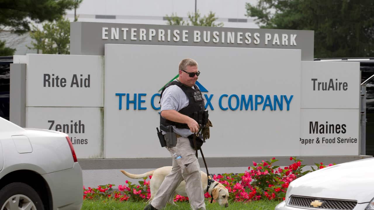 ATF police officer with a sniffing dog walks out the industrial complex Aberdeen.