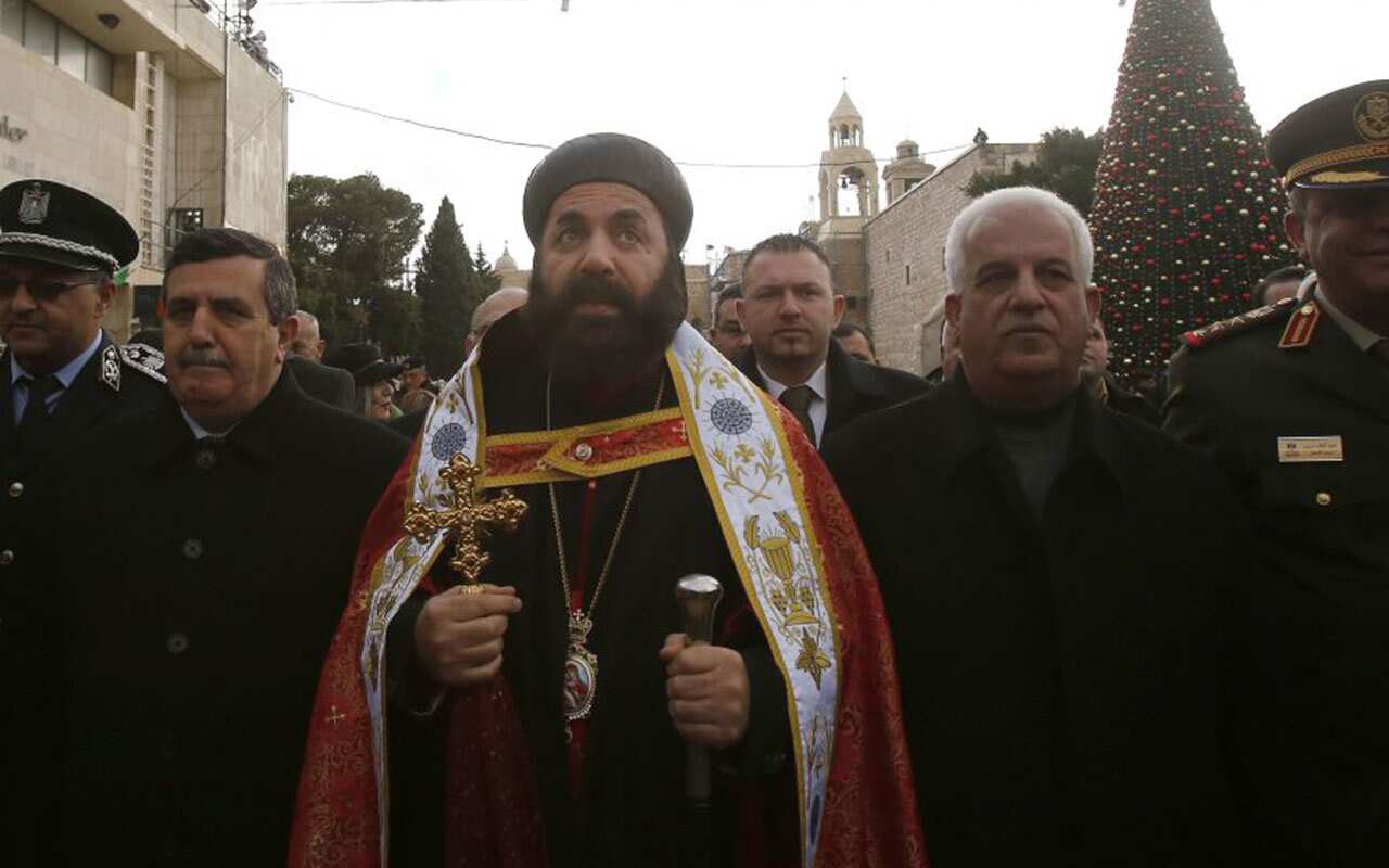 Syriac Orthodox Archbishop of Jerusalem Swerios Malki Murad (C) walks outside the church of the nativity.