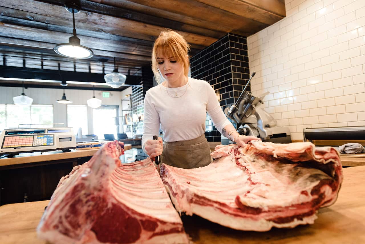 Kate Kavanaugh breaks down a rack of beef ribs at her shop, Western Daughters Butcher Shoppe, in Denver, July 27, 2019. Kavanaugh calls herself an ethical butcher, offering meat from animals bred on grassland and pasture, with animal well-being, environme