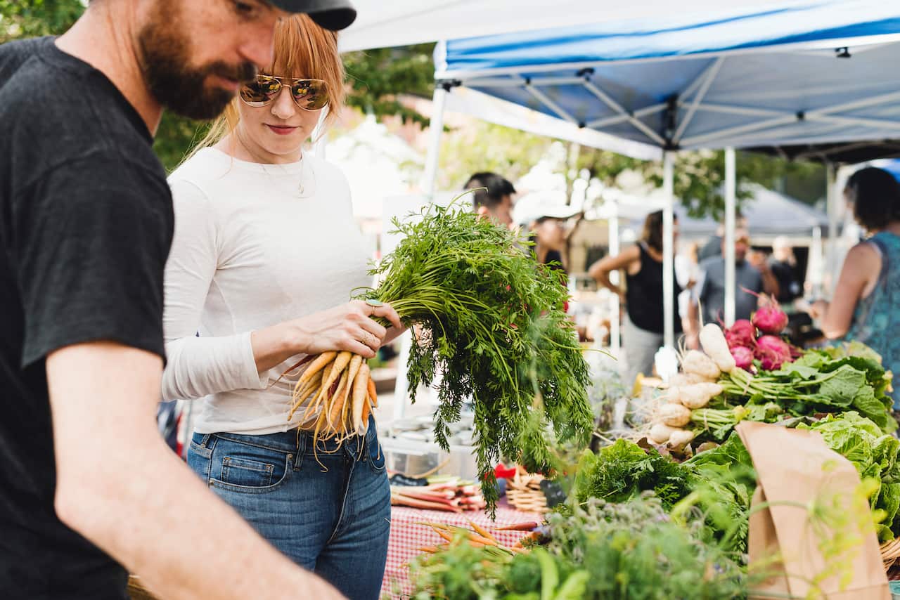 Butcher Kate Kavanaugh, who eats a mostly vegetable-based diet, shops at a farmers’ market with Josh Curtiss, her business partner, in Denver, July 27, 2019. Ka