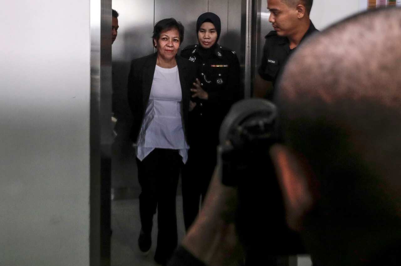Australian defendant Maria Elvira Pinto Exposto reacts inside a lift as she is escorted by Malaysia Customs officer (AAP)