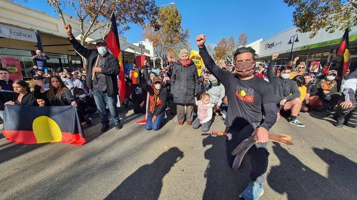 Former NRL player and Wiradjuri man Joe Williams kneels with protesters at Wagga Wagga Black Lives Matter rally. 