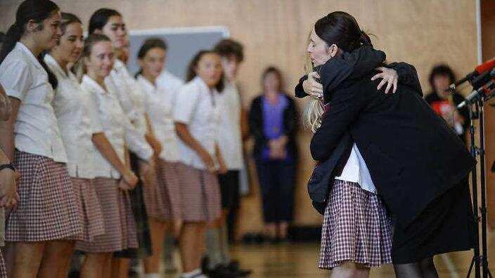 Prime Minister NZ hugs and consoles a student during a high school visit in Christchurch