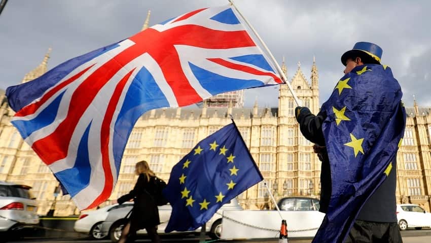 An anti-Brexit demonstrator waves a Union flag alongside a European Union flag outside the Houses of Parliament in London.
