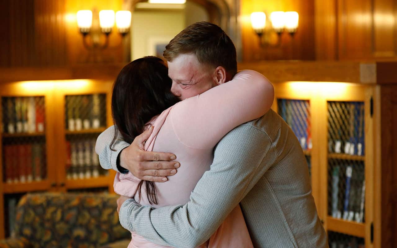 Lilly Ross, left, hugs face transplant recipient Andy Sandness as they first meet in a library at the Mayo Clinic.