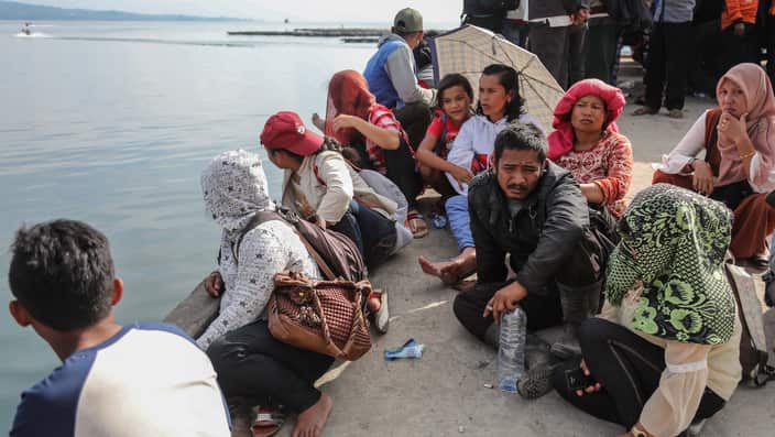 elatives of the victims on the sunken ferry KM Sinar Bangun sit and wait for news at Tigaras port.