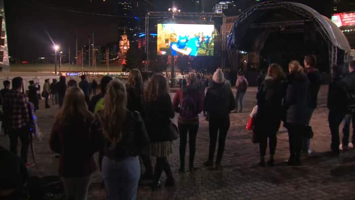People gather at Federation Square for Lee Lin Chin's final bulletin for SBS World News.