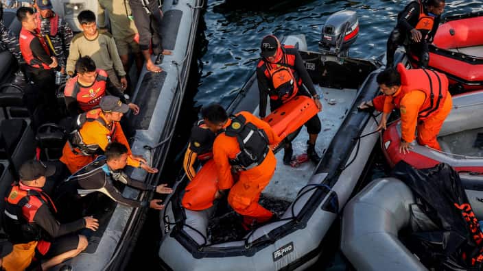 Member of an Indonesian search and rescue team prepare their dive gear as they search for victims.