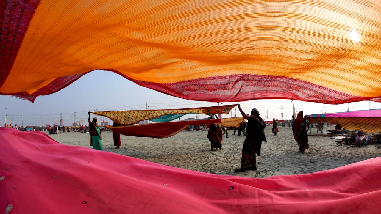 Hindu devotees dry their clothes after taking spiritual cleansing dips at the Sangam.