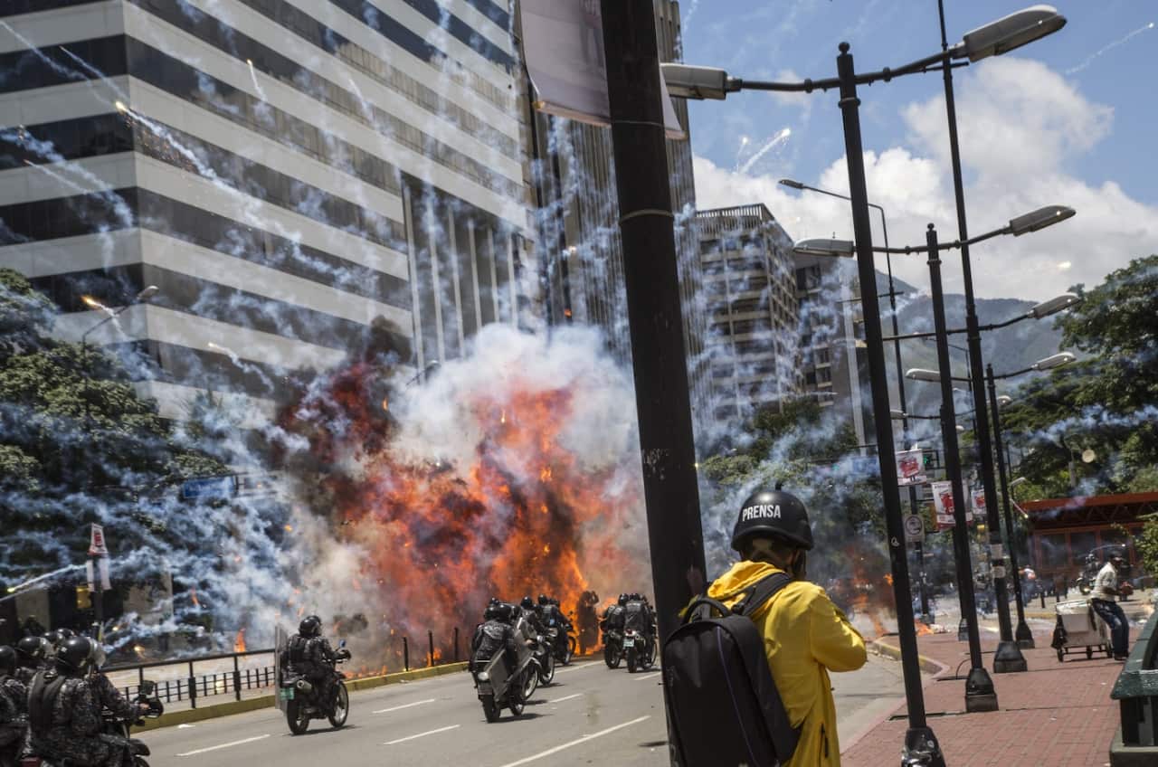Venezuelan police officers ride motorcycles as clashes erupt between protesters and police during vote on July 30, 2017, as Venezuelans cast ballots