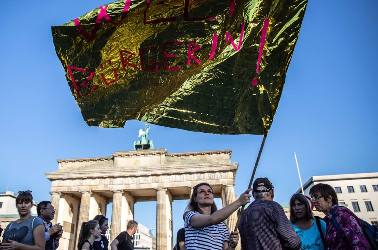 A demonstrator waves a flag , during a mass protest under the title '#unteilbar' in Berlin,