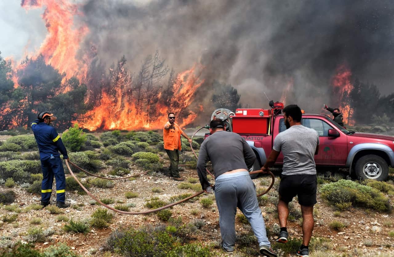 Firefighters and volunteers try to extinguish a wildfire raging in Verori, near Loutraki city, Peloponnese, southern Greece, 24 July 2018.