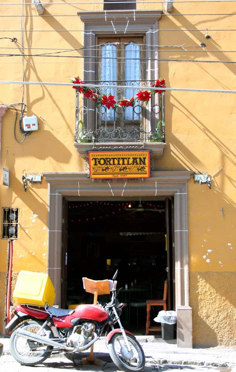 A delivery motor-bike parked in front of a tortilla restaurant in Mexico