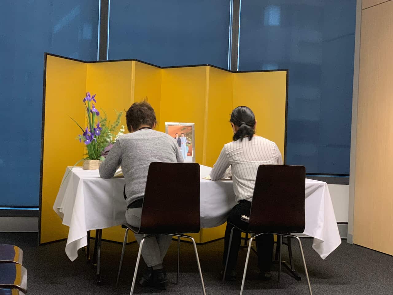 Well-wishers in Sydney write messages in the congratulatory book at the Japanese Consulate. 